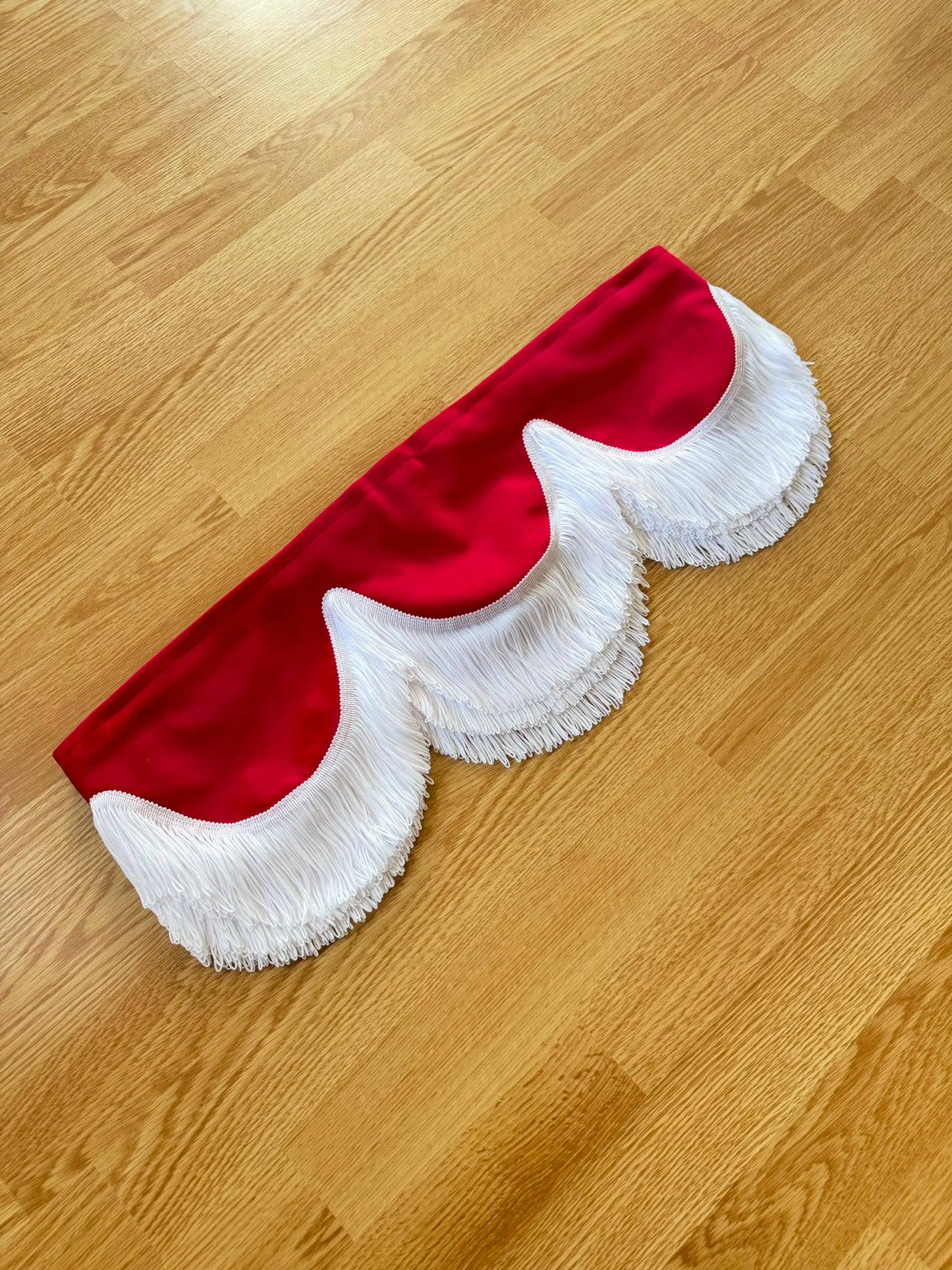 Rødt frontkappe med hvite frynser på lager